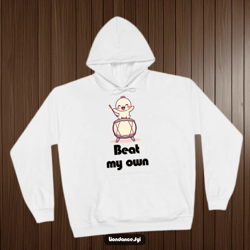 Funny hoodie featuring a playful character balancing on a stylized drum, ideal for staying warm with musical humor.